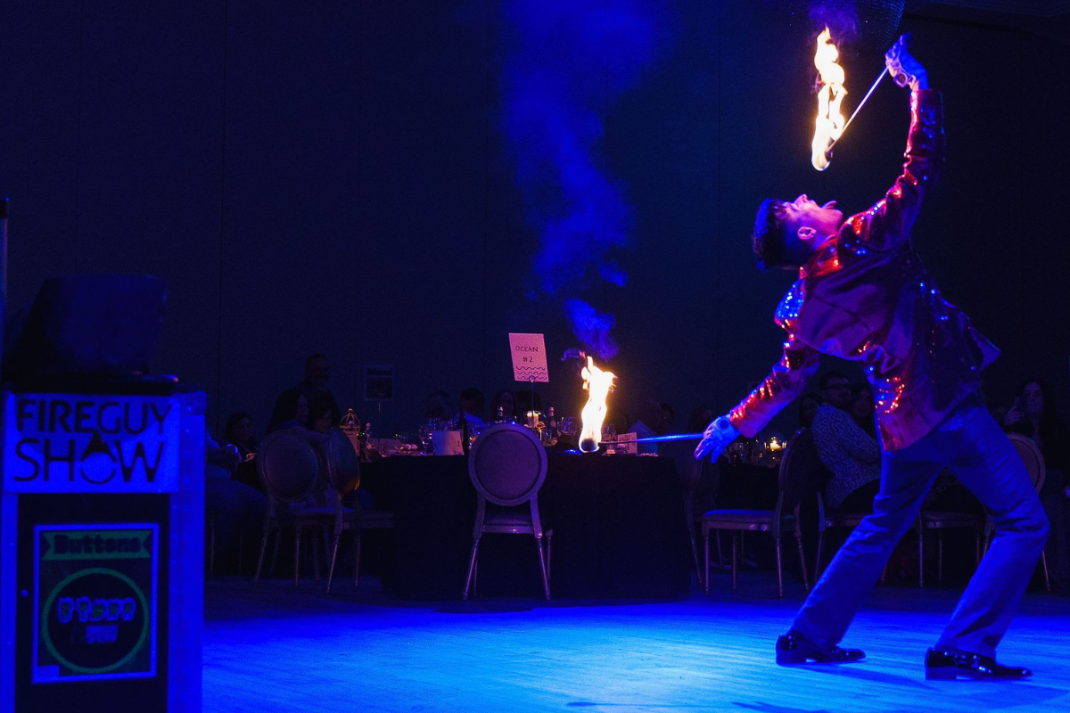 FireGuy eating fire at a fancy dress banquet.