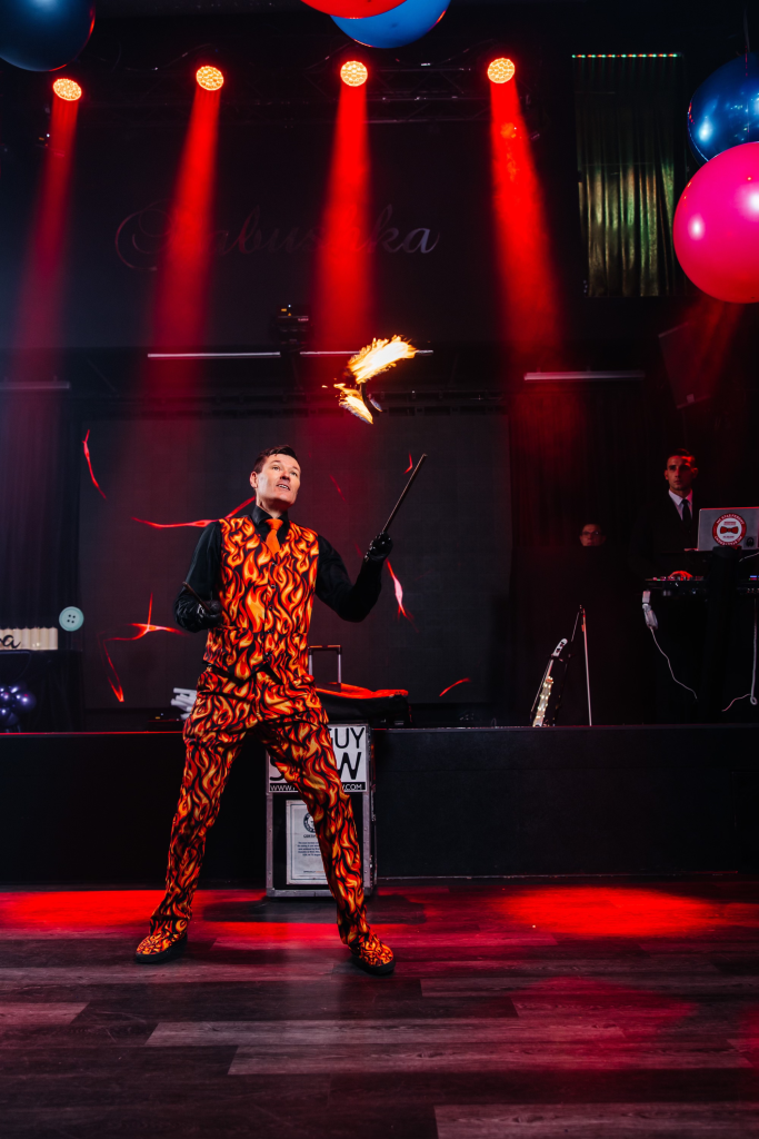 FireGuy juggling on stage inside.